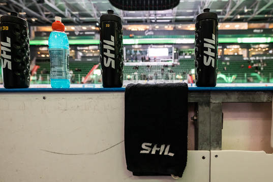 Vattenflaskor och handduk med texten ”SHL”