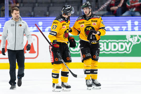 Luleås David Lilja lämnar isen med hjälp av Linus Omark