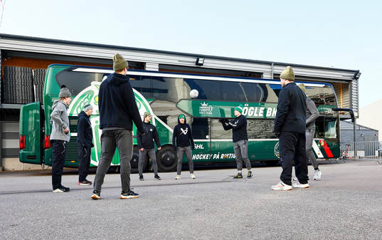 Rögles spelare värmer upp intill spelarbussen