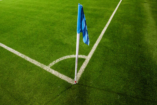 En hörnflagga i Djurgårdens färger på konstgräset i