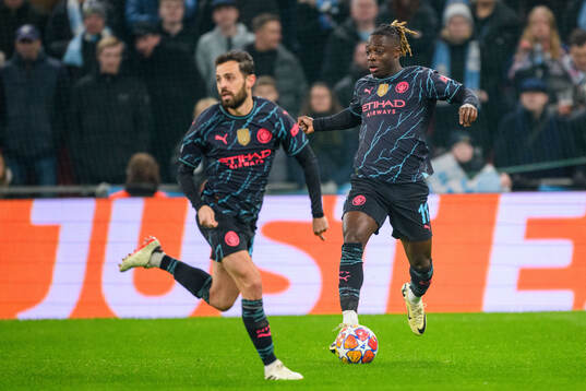 Jérémy Doku and Bernardo Silva of Manchester City
