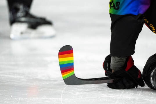 En klubba med pride-färgad tejp