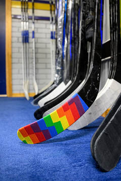 En klubbe tejpad med tejp i regnbågsfärger i HV71s