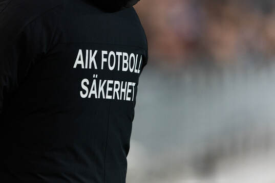 Ryggen på en jacka med texten AIK FOTBOLL SÄKERHET