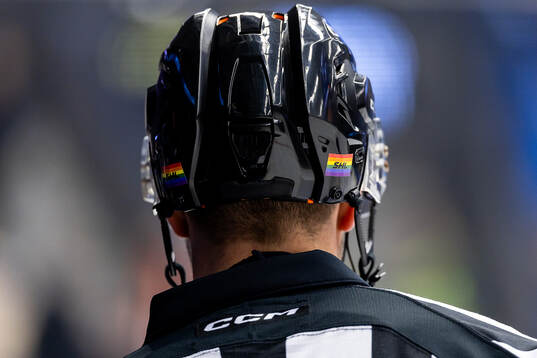 Domare med prideklistermärken på hjälmen