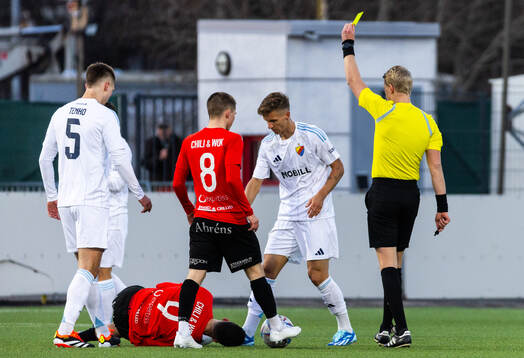 Domare Adam Ladebäck delar ut ett gult kort till