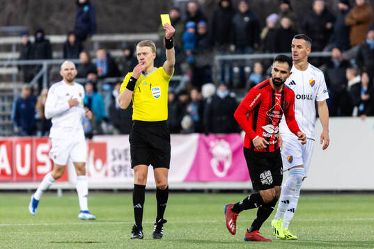Domare Adam Ladebäck delar ut ett gult kort till Nordic
