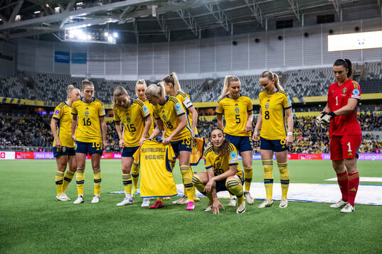 The starting eleven of Sweden hold a shirt with a message