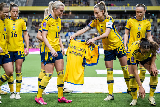 Josefine Rybrink and Nathalie Björn hold a shirt with a