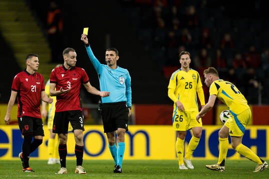 Mario Mitaj of Albania receives a yellow card from Referee