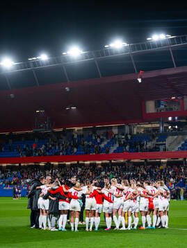 Players and staff of Brann gather in a circle