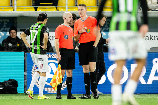Domare Oscar Johnson diskuterar med assisterande domaren