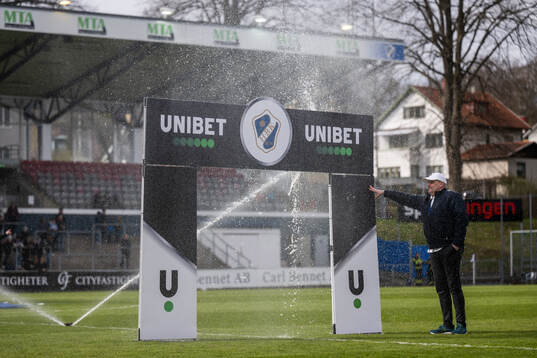 En person står och håller en Unibetskylt när