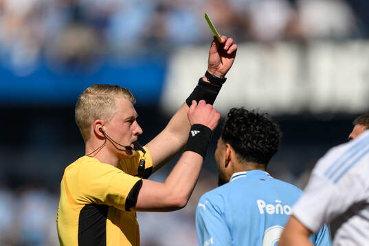 Domare Adam Ladebäck visar ett gult kort till Malmö FFs