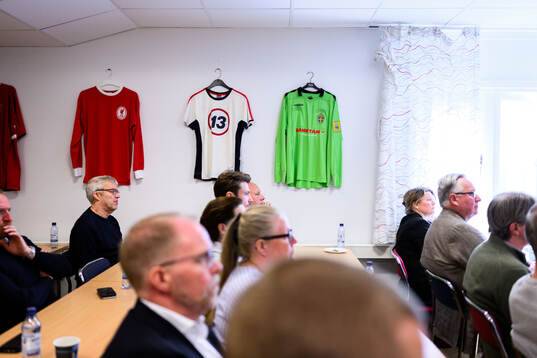 Fotbollströjor på väggarna vid ett möte hos Skånes