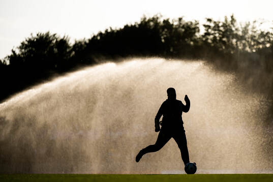 A silhouette of a player warming up