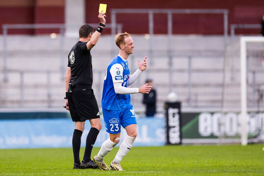 Domare Magnus Lindgren delar ut ett gult kort till IK