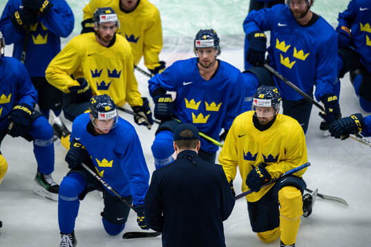 Players gather around head coach Sam Hallam of Sweden at a