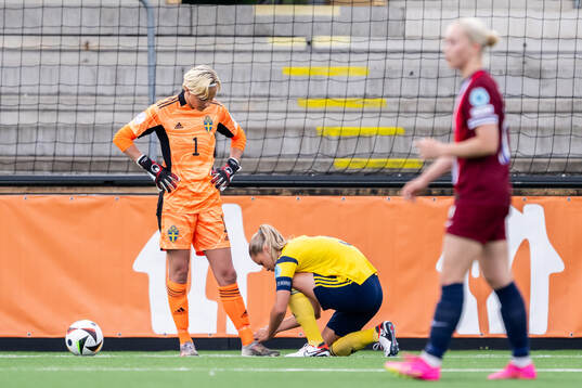 Alice Broman helps goalkeeper Saga Andersson of Sweden with