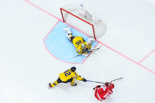 Jesper Frödén and goaltender Filip Gustavsson of Sweden