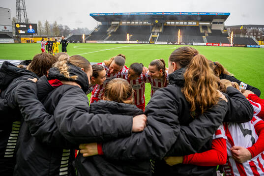 Casandra Luthcke and players of TIL 2020 gather in a circle