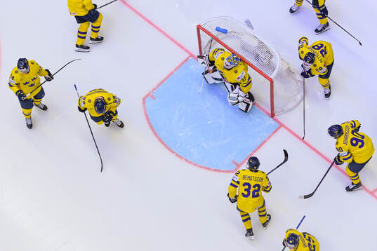Players of Sweden gather around goaltender Samuel Ersson