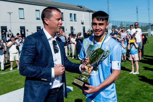 Malmö FFs Alexander Hughes tar emot pokalen av Malmö FFs