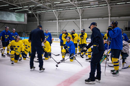 The players of Sweden gather around head coach Sam Hallam