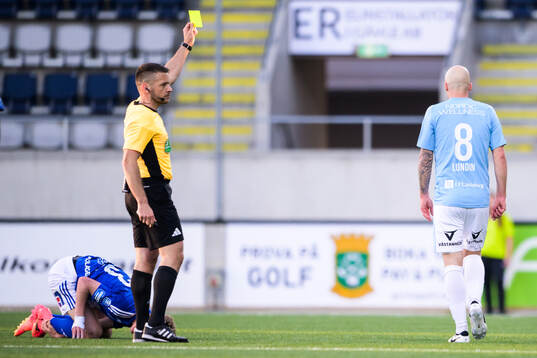 Domare Jovan Krsmanovic delar ut ett gult kort till Gefles
