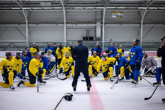 The players of Sweden gather around head coach Sam Hallam