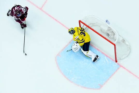 Roberts Bukarts of Latvia and goaltender Filip Gustavsson