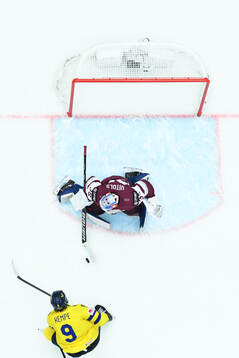Adrian Kempe of Sweden and goaltender Kristers Gudlevskis