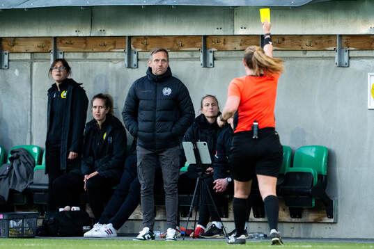 Domare Sandra Almkvist delar ut ett gult kort till