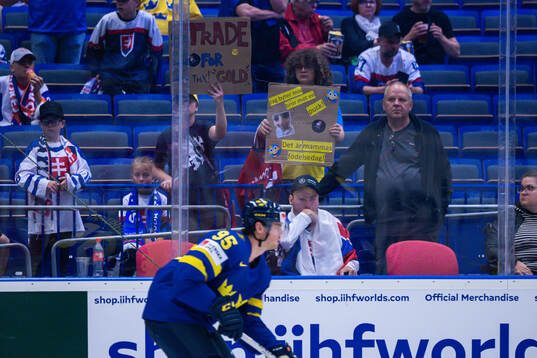 Supporters with signs in front of André Burakovsky of