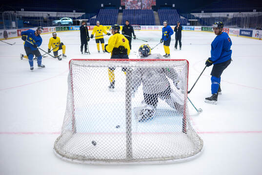 Adrian Kempe (L) and goaltender Filip Gustavsson of Sweden