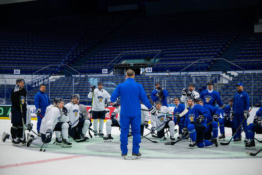 Players of Finland gather around head coach Jukka Jalonen