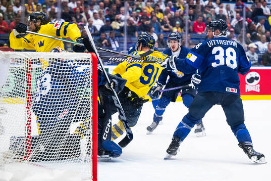 Goaltender Emil Larmi of Finland and Carl Grundström of