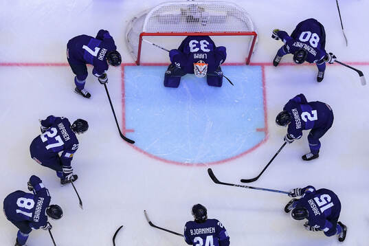 Players of Finland gather around goaltender Emil Larmi of