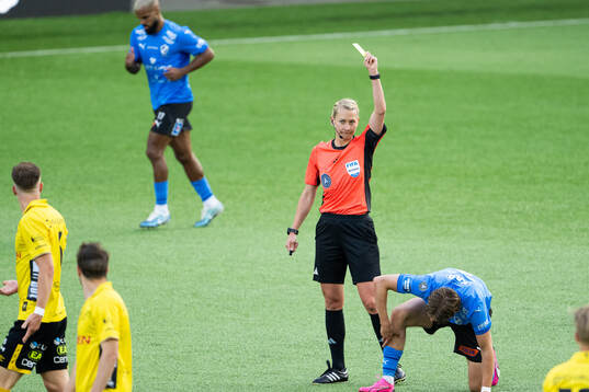 Domare Tess Olofsson delar ut ett gult kort