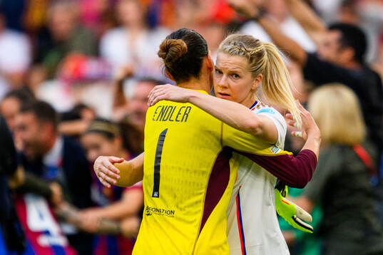 Ada Hegerberg of Lyon hugs goalkeeper Christiane Endler