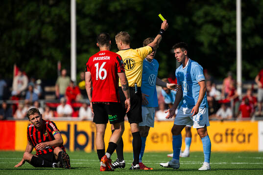 Domare Glenn Nyberg visar det gula kortet till Malmö FFs