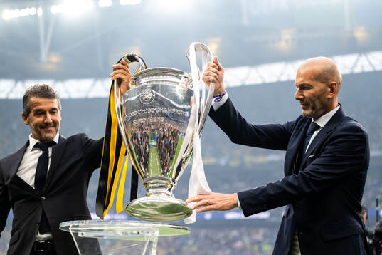 Former players Karl Heinz Riedle and Zinedine Zidane carry