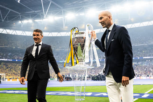 Former players Karl Heinz Riedle and Zinedine Zidane carry