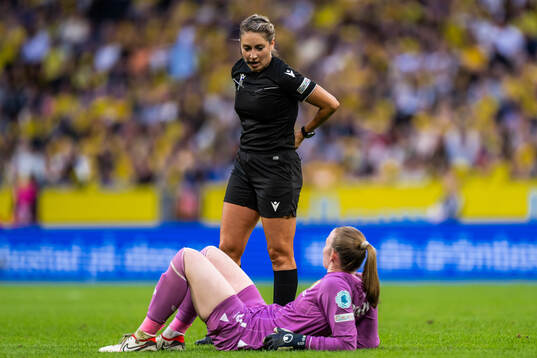 Referee Alina Peşu talks to goalkeeper Courtney Brosnan of