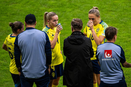 Hanna Lundkvist and Fridolina Rolfö talk to head coach
