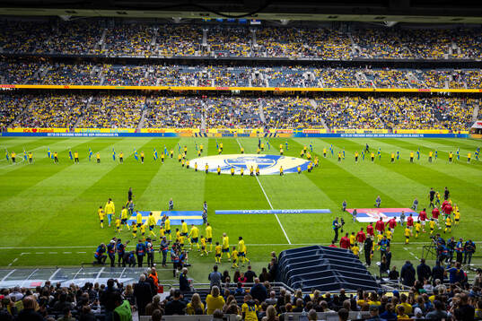 Players from Sweden and Serbia enter the pitch