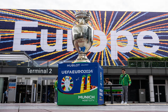 Tournament logo and a trophy replica at Munich Airport