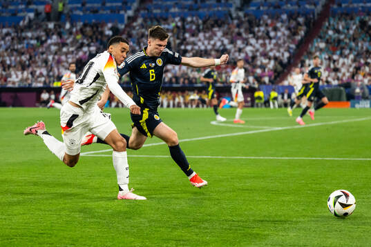 Jamal Musiala of Germany and Kieran Tierney of Scotland