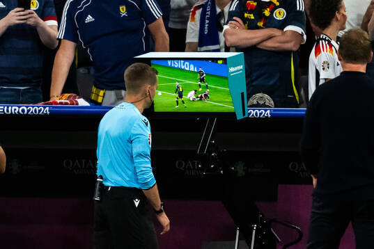Referee Clément Turpin checks a screen