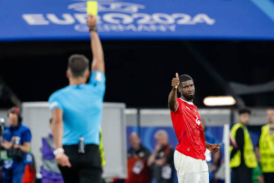 Kevin Danso of Austria receives a yellow card